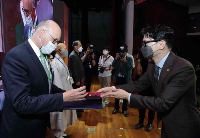 한동훈 법무부장관이 ‘올해의 이민자상’을 수상한 엠마 프라이싱거를 대신하여 볼프강 앙거홀처<br>
주한 오스트리아 대사에게 대통령 표창을 수여하고 있다.