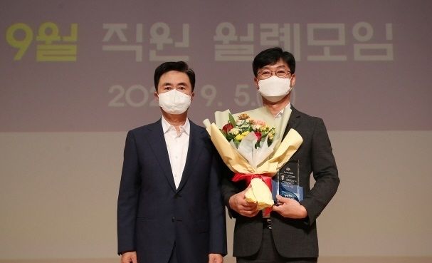 김태흠 충남도지사가 권민식 해양정책과 사무관에게 8월의 우수직원 상장을 전달한 후 기념촬영하고 있다.