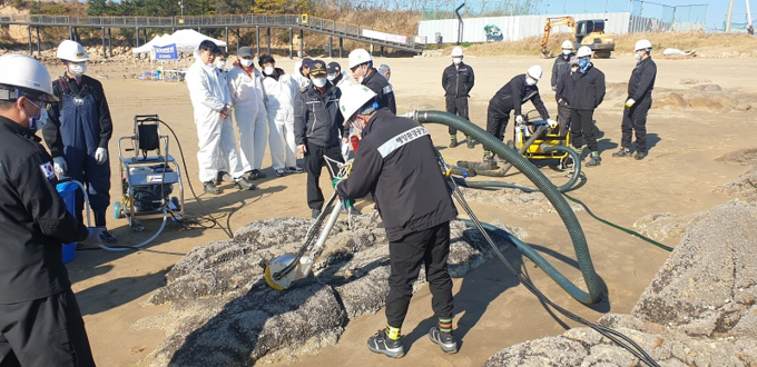 (참고사진)해안가에 떠밀려와 암벽에 붙어있는 기름을 제거하기 이해 고압분사기로 기름을 제거하고 _