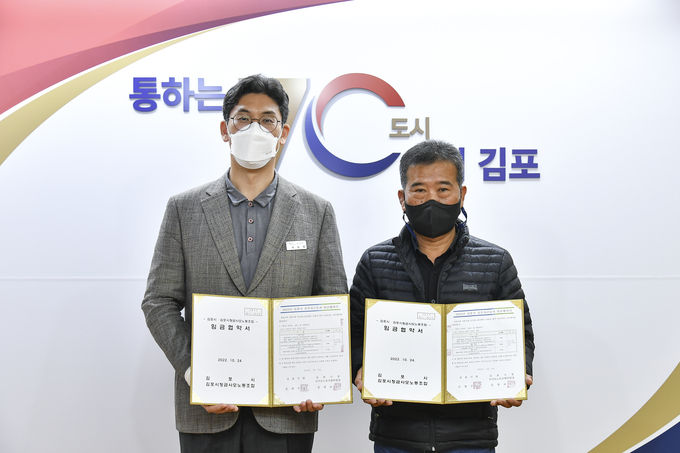 지난 24일 시청 본관 2층 접견실에서 열린 공무직 임금협약 체결식. 사진 왼쪽은 허승범 김포 부시장, 오른쪽은 심명보 금사모 위원장이다