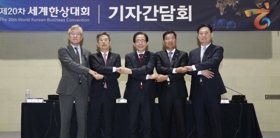 31일 울산 울주군 울산전시컨벤션센터에서 열린 제20차 세계한상대회 기자간담회에서 박기출 PG홀딩스그룹 회장(왼쪽부터), 안효대 울산시경제부시장, 김성곤 재외동포재단 이사장, 김점배 제20차 세계한상대회 대회장, 최상민 ESD 대표가 손을 맞잡고 있다