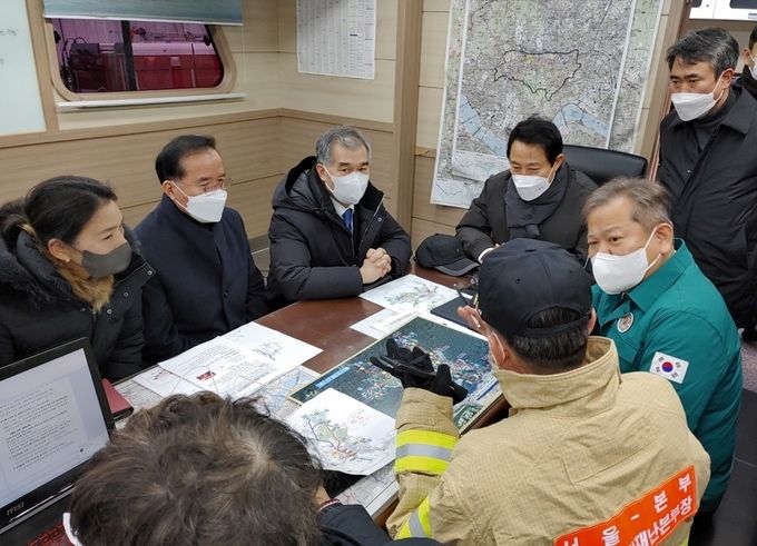 이상민 행정안전부 장관이 20일 오전 서울시 강남구 구룡마을 화재 현장을 방문하여 소방관계자로부터 상황보고를 받고 있다. 이장관은 대피주민 난방 등 생활에 불편함이 없도록 필요한 조치를 할 것을 당부하였다.