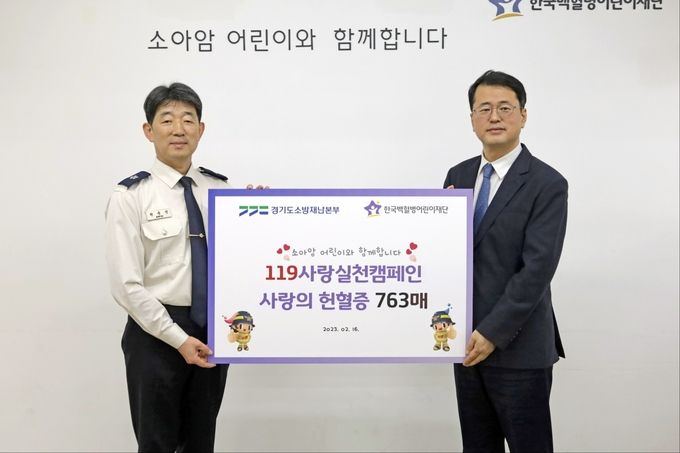 권용성 경기도소방재난본부 소방행정과장(사진 왼쪽)이 서선원 한국백혈병어린이재단 사무총장에게 헌혈증서를 기부한뒤 기념촬영을 하고 있다