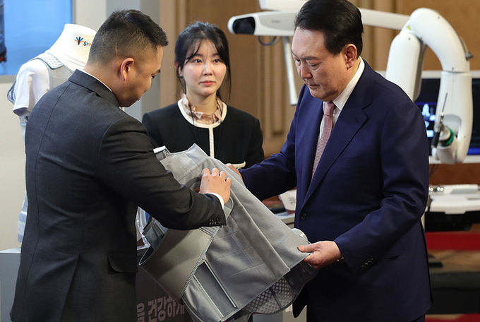 윤석열 대통령이 지난 2월 28일 청와대 영빈관에서 열린 바이오헬스 신시장 창출전략 회의에 앞서 VNTC의 ICT 하이브리드 척추측만증 보조기를 관람하고 있다.