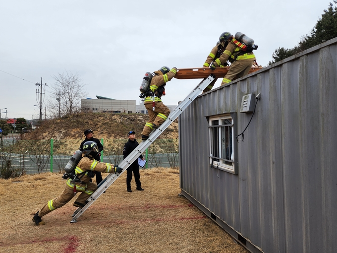 도 구조전술 경연대회 참가팀이 사다리를 이용해 장애물로 가정한 컨테이너를 넘고 있다.
