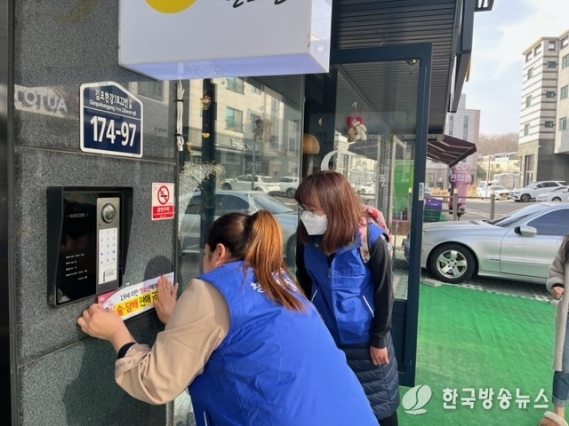 마산동 청소년지도위원들이 술·담배 판매 금지 업소 스티커 부착 중이다