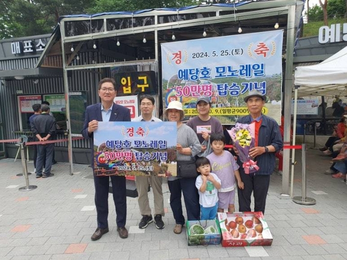 예당호 모노레일 50만번째 방문객 채용병 씨 가족(78세, 천안 거주)과 도중선 부군수 기념 촬영