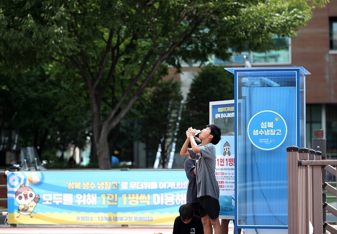 무더위가 기승을 부린 14일 오후 서울 성북구 바람마당에 설치된 ‘생수 나눔 냉장고’에서 학생들이 생수를 꺼내 목을 축이고 있다. 2024.7.14(ⓒ뉴스1)
