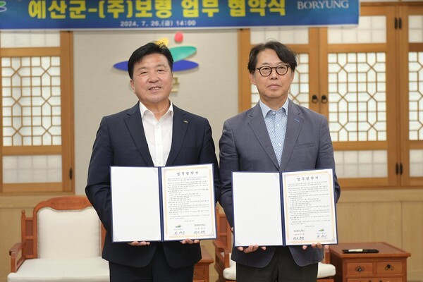최재구 예산군수(왼쪽)와 ㈜보령 장두현 대표가 26일 황새 복원과 보전을 위한 업무협약을 체결하고 기념촬영을 하고 있다.
