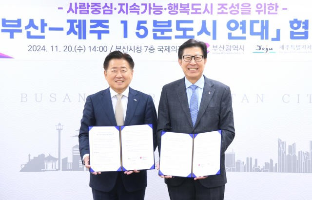 박형준 부산시장(오른쪽)과 오영훈 제주도지사(왼쪽)가 20일 부산시청 국제의전실에서 '15분 도시 연대 업무협약' 체결 후 기념 촬영을 하고 있다. 두 지자체는 지속 가능한 행복 도시 조성을 위해 협력할 것을 약속했다. 