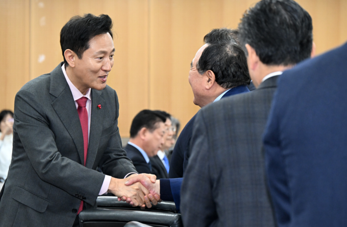 오세훈 서울시장이 10일(화) 서울시청에서 열린 '비상경제회의' 참석자들과 인사를 나누고 있다