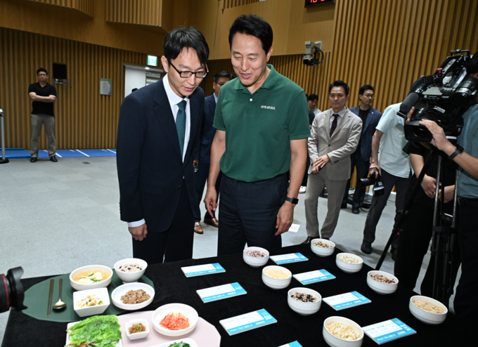 오세훈 서울시장이 10일(수) '9988 평생건강 서울' 기자설명회에서 정희원 건강총괄관과 저속노화 밥상을 살펴보고 있다.