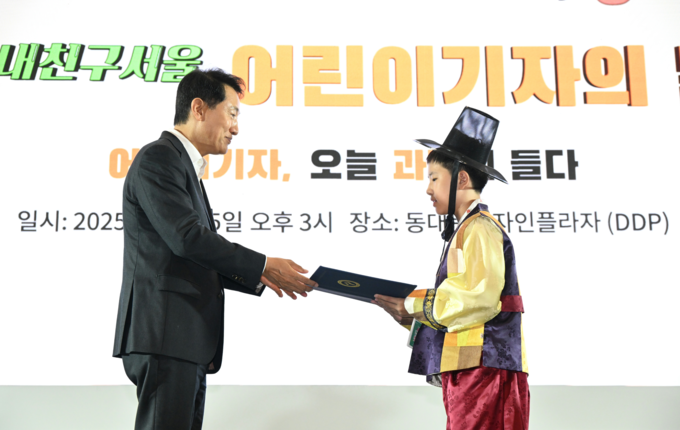 오세훈 시장이 25일(목) DDP 아트홀1에서 개최된 '2025 내친구서울 어린이기자의 날 행사'에서 모범 어린이기자에게 표창을 수여하고 있다.