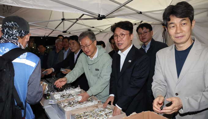 김민석 국무총리가 10일 서울 구로구 남구로 새벽인력시장을 찾아 근로자들에게 떡을 나눠주고 있다.